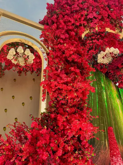 A detail of the floral decor, where a wall of red flowers meets a digital screen, creating a seamless blend of nature and technology.