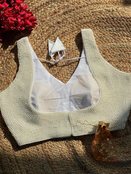 For a timeless and elegant option, I offer this handcrafted blouse in a beautiful off-white pearl finish. It's made with pure silk and is alterable to ensure a perfect fit.