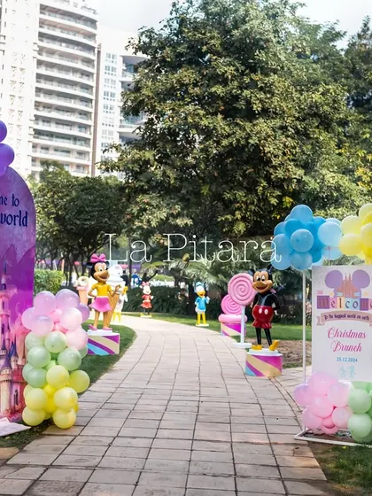 The walkway into the Disney-themed party, lined with colorful balloon displays and life-sized cutouts of beloved characters like Goofy and Minnie Mouse, creating a joyful and exciting entrance path.