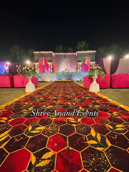 A perfectly symmetrical view down a grand aisle, leading to a beautifully decorated stage, showcasing the scale of our outdoor setups.