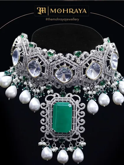 A close-up of the emerald and pearl choker, highlighting the hexagonal uncut stones and the intricate diamond work.