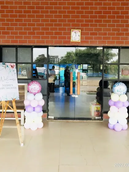 The entrance to a baby shower venue, with a welcome easel and balloon pillars.