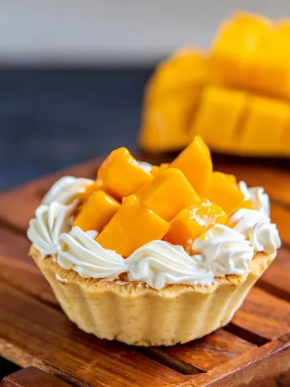 Our Mango Custard Tart is a bite of sunshine. A buttery, crisp tart shell is filled with creamy custard and topped with a generous amount of fresh, juicy mango.