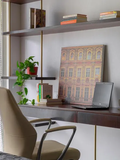 Whether it's for diving into books or sketching out ideas, this study nook is designed to spark imagination. The floating dark wood desk is complemented by brass supports and open shelving for displaying personal treasures.