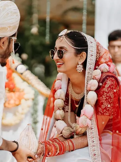 A candid shot of the bride smiling at her groom during their outdoor wedding ceremony.