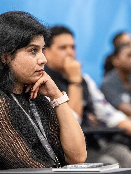 A participant at our conference, listening thoughtfully to a discussion on modern S&C practices.