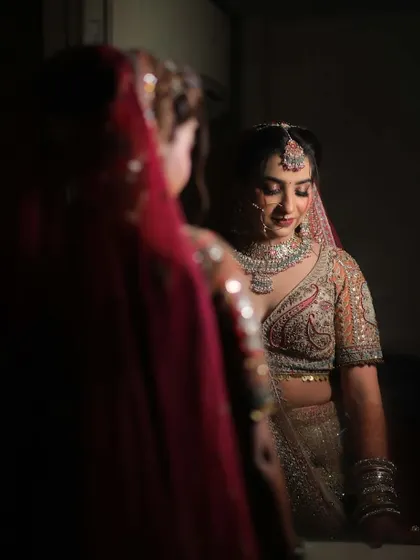 A bride's reflection in the mirror, capturing a quiet moment of admiration for her complete bridal look, featuring our sparkling diamond-look jewellery.