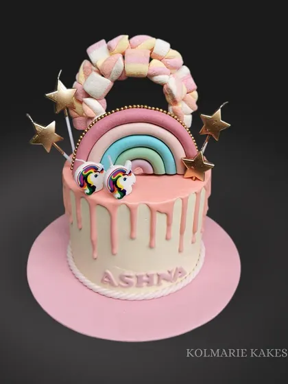 Another take on the unicorn theme, this time with a rainbow made of marshmallows! This drip cake is decorated with star candles and unicorn toppers for a fun, magical look.