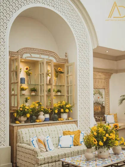 A comfortable lounge area for guests at the Haldi function, with custom-printed cushions and floral arrangements that continue the sunny yellow theme.