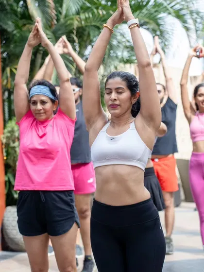 This image captures a moment of collective focus during an outdoor corporate yoga session. Practicing together in a natural setting enhances the stress-relieving benefits of yoga.