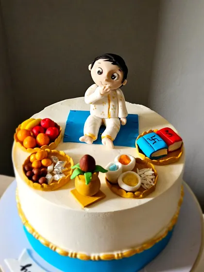 A close-up of the Annaprasan cake, showing the baby figurine and the miniature edible offerings like fruits, sweets, and books.