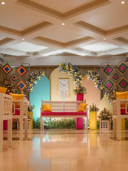 A wide view of our modern and colorful Mehendi seating arrangement, designed to be both comfortable for the bride and visually stunning for photos.