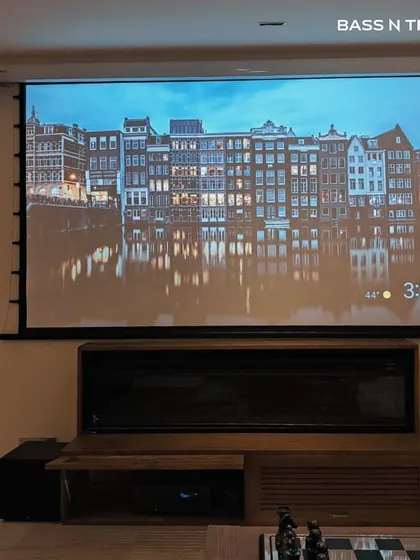 A roll-down projector screen paired with a full speaker system offers the best of both worlds. Enjoy a massive screen for movie nights and reclaim your wall when it's not in use.
