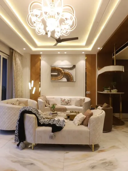 In this Delhi home, I used a warm brown-beige palette with chevron veneer patterns and a stunning chandelier to create a living space that radiates classic sophistication.