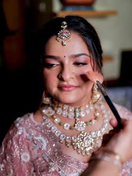 A behind-the-scenes moment, applying blush to create that perfect bridal flush on the cheeks.