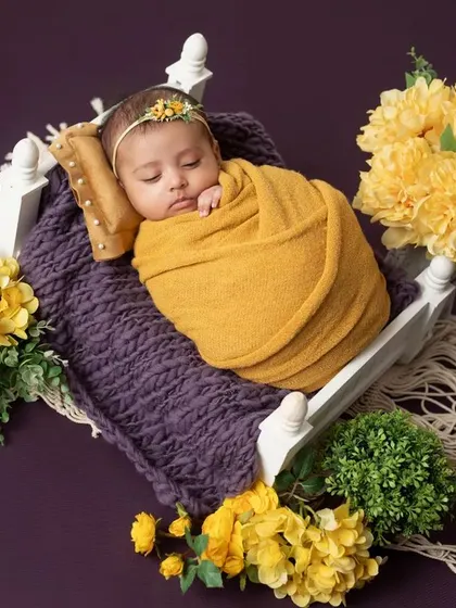 A full view of the yellow and purple themed setup, with the baby sleeping in a miniature bed.