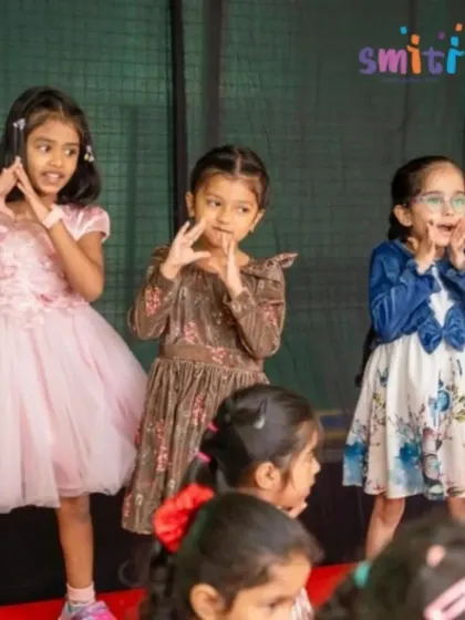 Three girls perform a dance with expressive hand gestures. Our performance arts program helps children develop their storytelling abilities through movement.
