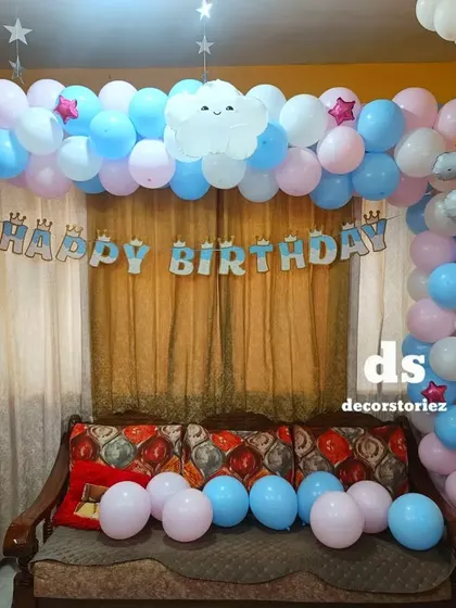 A sweet and dreamy rainbow and unicorn themed birthday. This home setup features a pastel balloon arch with a unicorn foil, rainbow, and cloud details for a magical celebration.