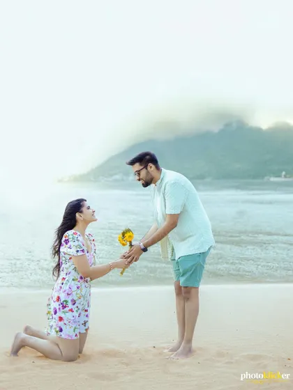 A romantic gesture on the beach, as the woman kneels to offer her partner a sunflower, reversing the traditional proposal pose.