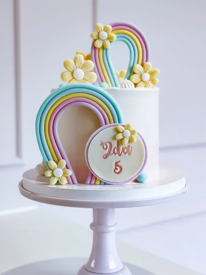 A gorgeous rainbow cake with delicate flowers and intricate details.