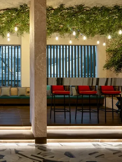 For this commercial project, I designed an indoor bar and lounge area with integrated planters and artificial trees. The string lights and natural elements create a relaxed, cafe-like atmosphere indoors.
