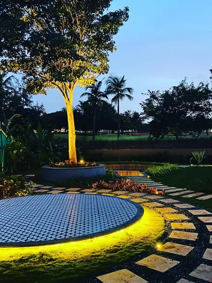 A beautiful composition of the lit patio and pathway under a twilight sky.