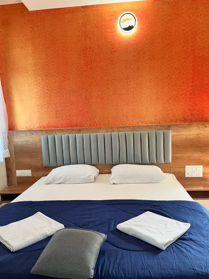 A look inside our premium hill view rooms, featuring a comfortable bed and modern amenities for a relaxing stay.