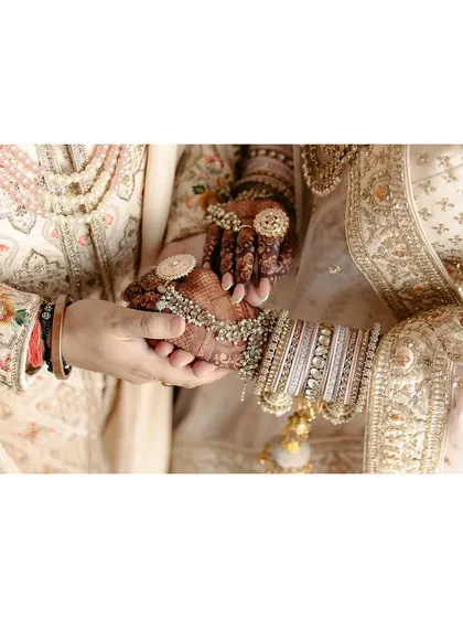 A close-up of the couple holding hands, a simple yet powerful symbol of their union and promise.