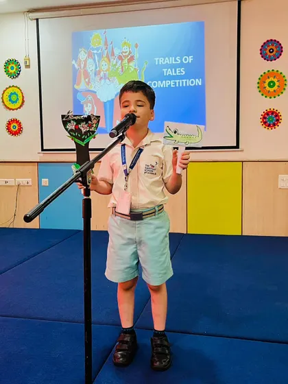 With a dragon puppet in hand, this student passionately narrates a fantasy tale, showcasing his confidence and creativity.