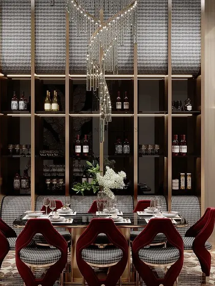 A closer view of the dining area within a double-height space. The spiral chandelier acts as a centerpiece, complemented by a built-in wine display and rich, red velvet chairs, making it a perfect setting for a formal dinner.