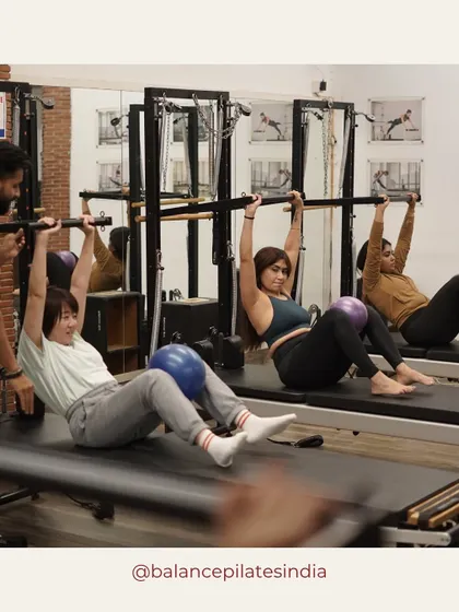 Our trainer providing an assist during a roll-down with the bar. This ensures proper form and deeper engagement.