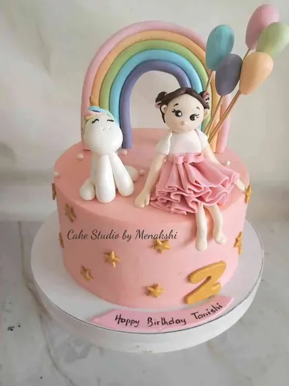 I created this cake for a baby doll who loves unicorns. It features a sweet little girl figurine sitting next to her unicorn friend, with a rainbow and balloons.