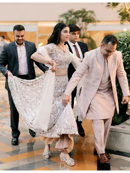 The bride making her entrance at the Roka ceremony, her brothers helping with her elegant lehenga.