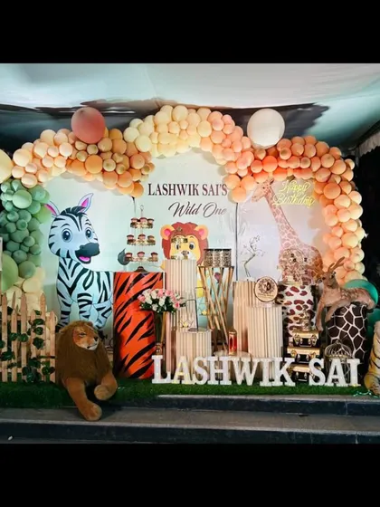 This "Wild One" setup for Lashwik Sai features a full cast of jungle animals, including a zebra and tiger, set against a backdrop of pastel-colored balloons for a softer, charming take on the theme.