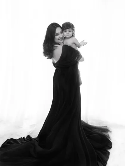A duplicate of image 1, this classic black and white portrait showcases the elegance of a mother and child bond. The flowing gown is available in my studio wardrobe for your session.