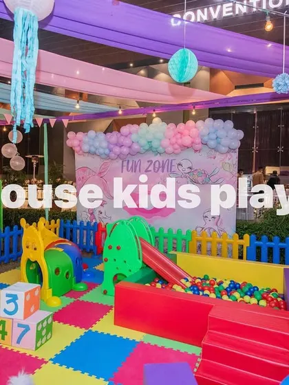 A shot of our 14x14 rainbow play area, showing the ball pit and caterpillar tunnel under colorful party drapes.