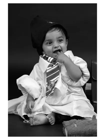 A playful moment from the "wizard" themed baby shoot, rendered in black and white for a classic and charming effect.