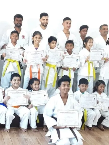 A group of students poses with their certificates after a successful belt test. Each certificate marks a new chapter in their karate training.