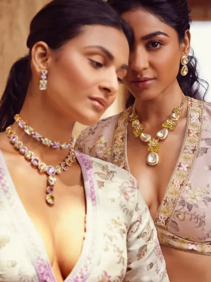 A close-up on two models, highlighting the contrast between a layered pastel necklace and a simpler, elegant one. This is key for creating visual interest in group styling.