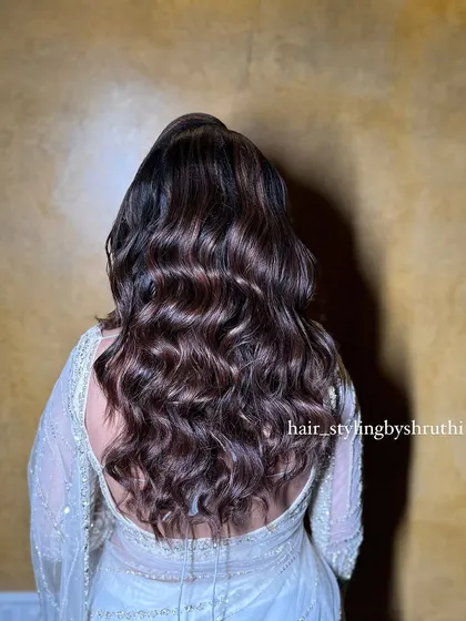 A stunning open hairstyle with rich, chocolate-brown waves. The hair has incredible shine and volume, creating a very glamorous and high-impact look.