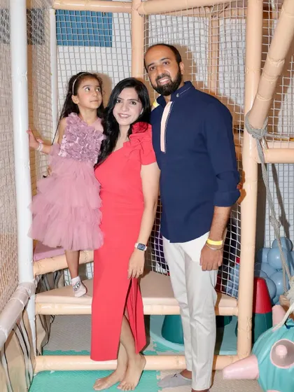 A family poses together inside the play structure, capturing a happy memory from the birthday celebration.