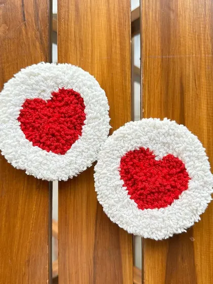 Another view of the red and white punch needle heart coasters, showing their plush texture. All colors are fully customizable.