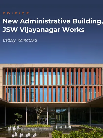 The New Administrative Building for JSW Vijayanagar Works in Bellary, Karnataka. The facade features terracotta-colored vertical fins that provide solar shading while creating a strong visual rhythm, set against a backdrop of blue sky.
