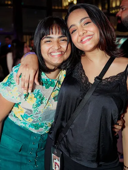 Two friends hugging and smiling. The sense of community and togetherness on the dance floor is a beautiful thing.