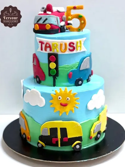 A three-tier transport-themed cake featuring a Mumbai auto-rickshaw, a double-decker bus, and cars. It's a vibrant and fun design for a 5-year-old who loves vehicles.