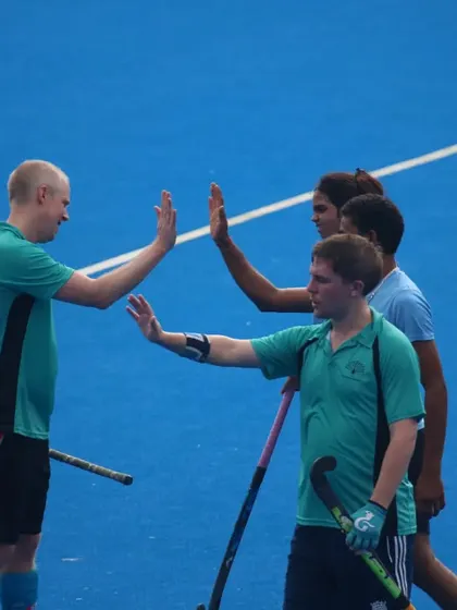 A high-five between teammates celebrates a good play. This simple gesture shows the positive reinforcement and teamwork we encourage on the field.
