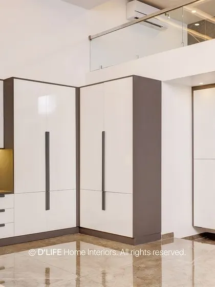 A view of the bedroom's integrated wardrobe and study unit, showcasing a clean, modern design with white and grey finishes that maximize space and light.