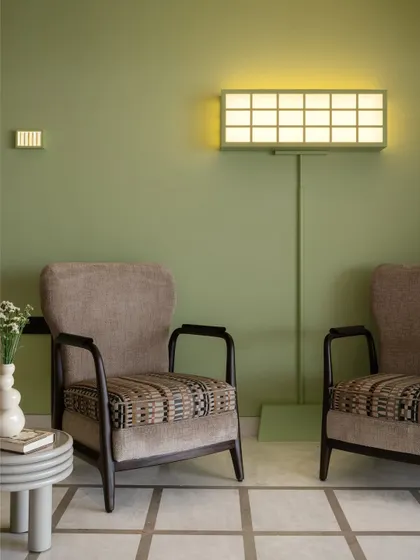 A cozy corner in the Gingham Dreams living room, featuring comfortable armchairs and a unique, custom-designed floor lamp that resembles a lightbox.