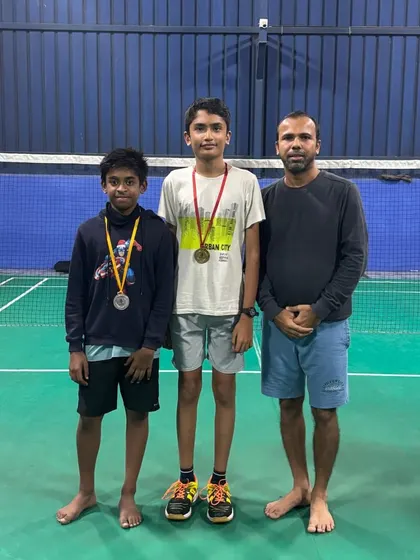 Two of our students proudly display their medals alongside their coach after competing in an academy tournament. We focus on building confidence through healthy competition.