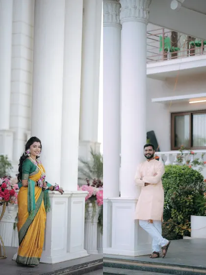 Individual portraits of the bride and groom against grand white pillars. These shots highlight their style and the elegance of their Haldi event.